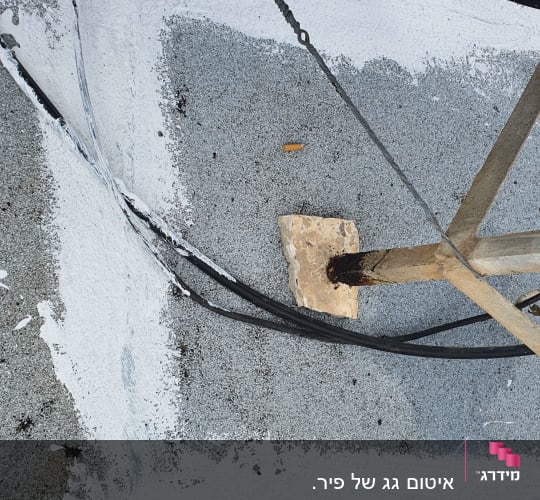 איטום גג עם חומר לבן וכבלים חשמליים